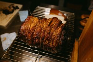 Close-up of a perfectly roasted meat joint on a grill rack, showcasing its crispy crust.